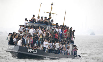 Жители Северной Кореи смотрят на китайское туристическое судно. Фото: totallycoolpix.com